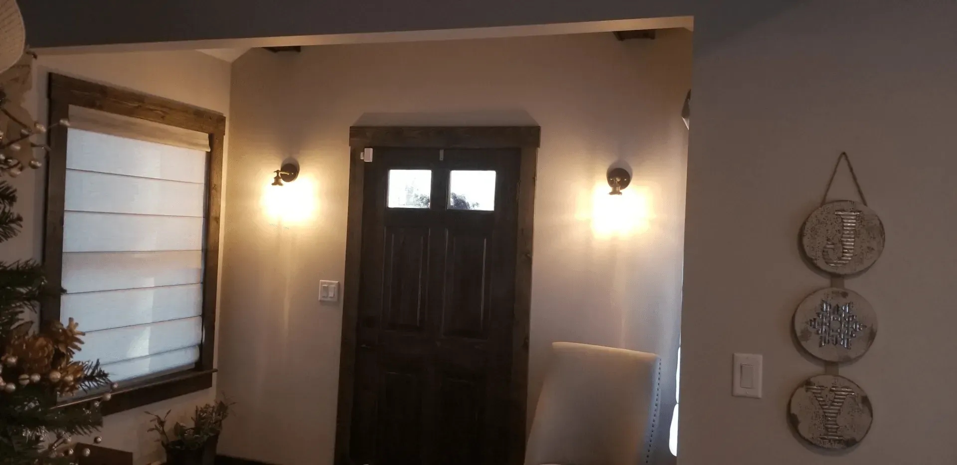 A hallway in a house with a door and two windows.