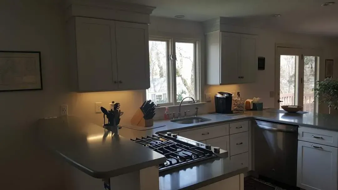 A kitchen with white cabinets and stainless steel appliances