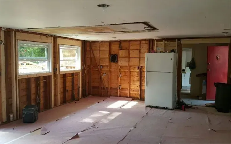 An empty room with a white refrigerator in it