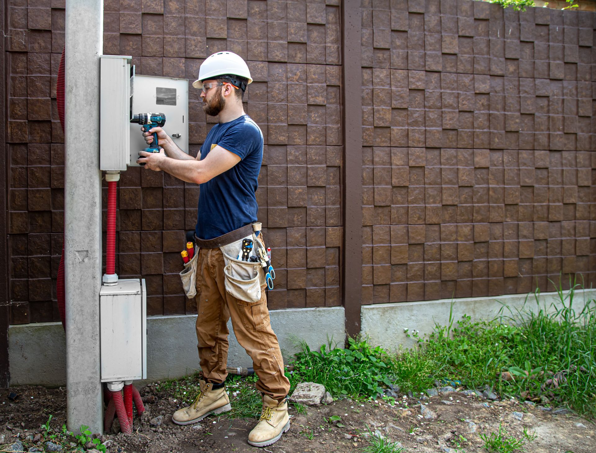 A man is working on a fence with a drill.