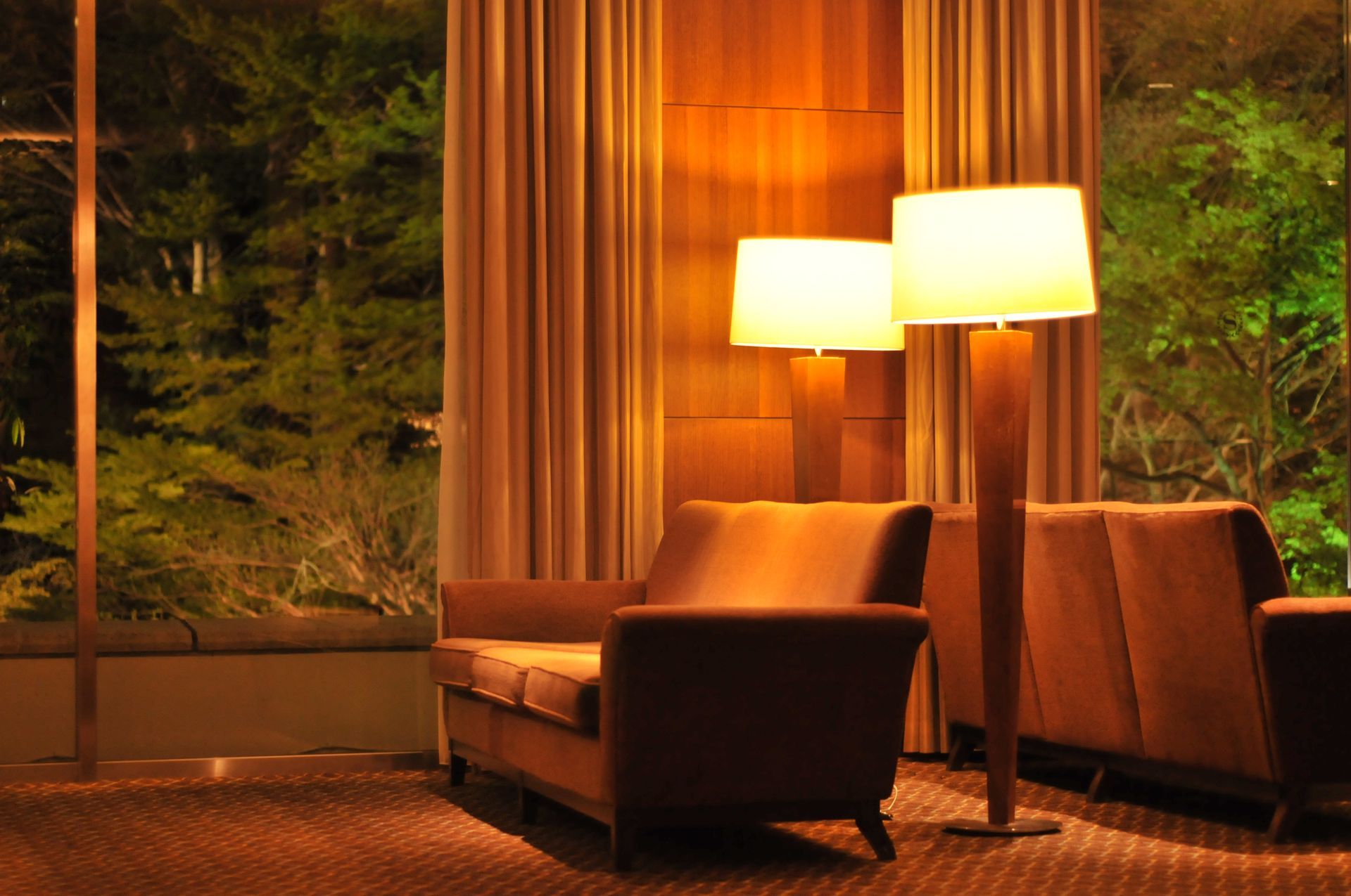 A living room with a couch and two lamps