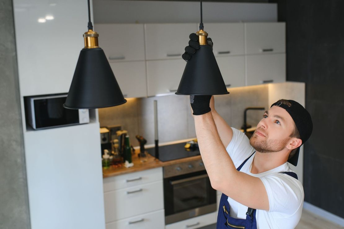 A kitchen with white cabinets and a chandelier hanging from the ceiling