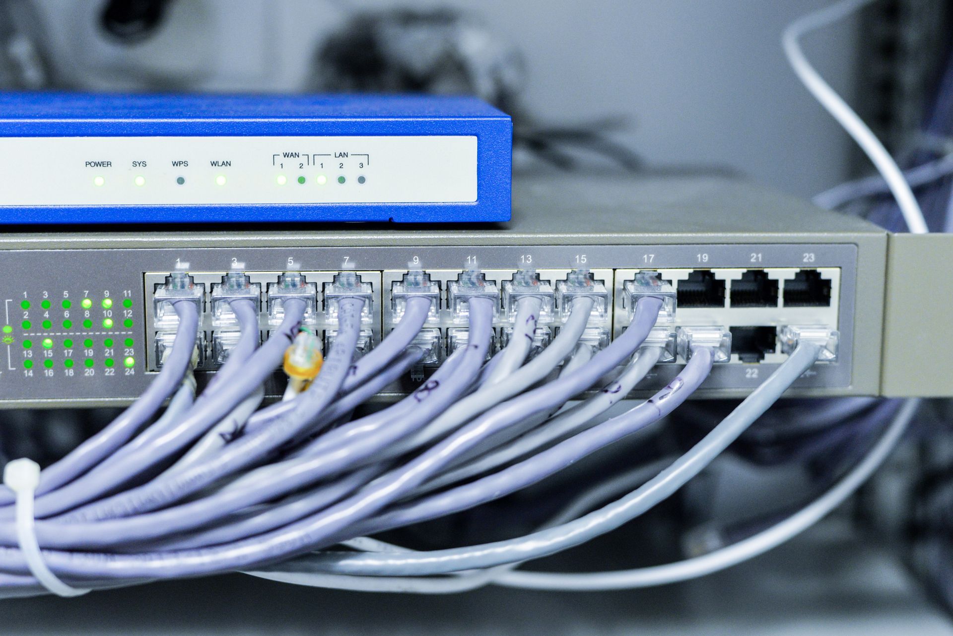 A bunch of wires are connected to a router in a server room.