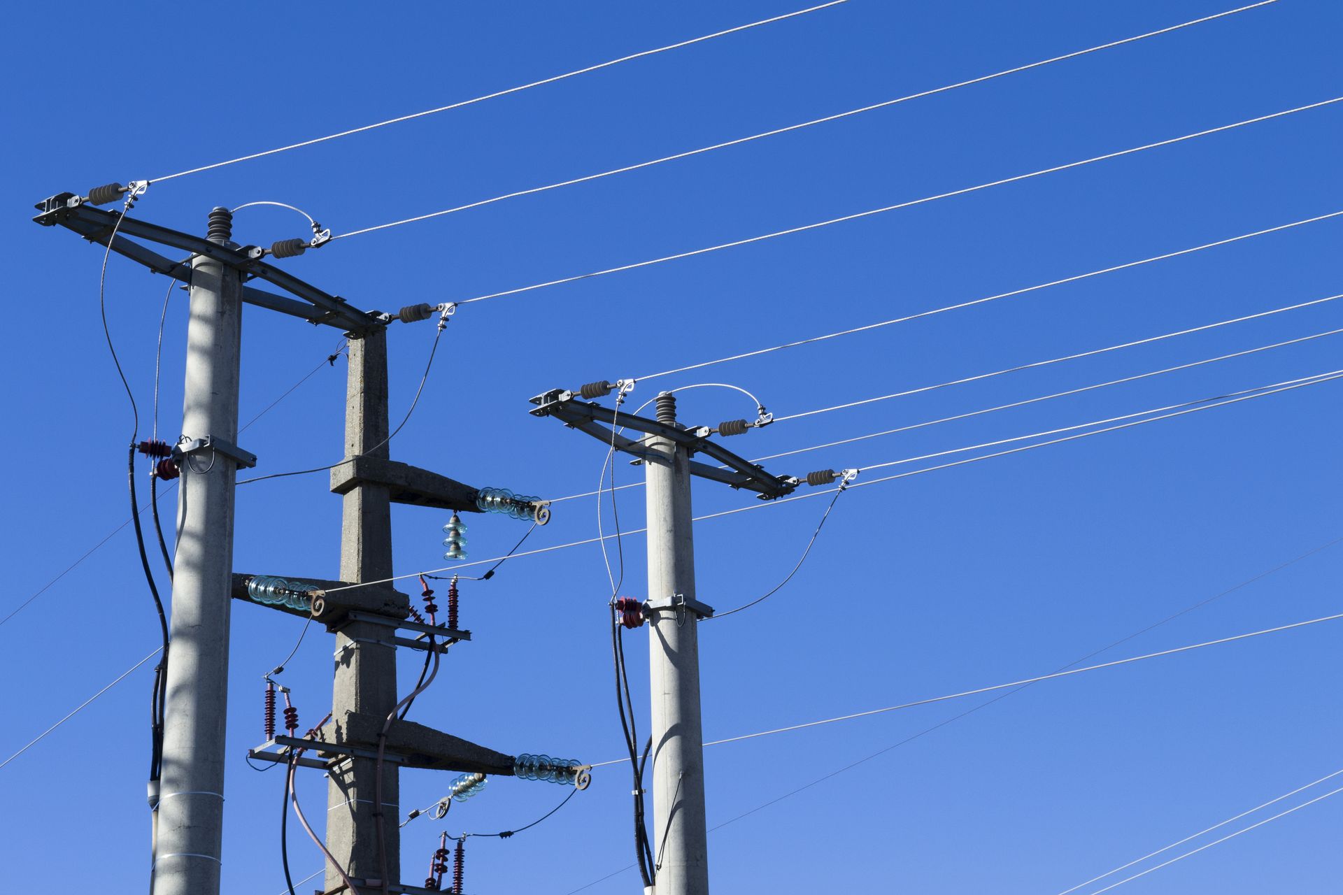 A row of power lines against a blue sky