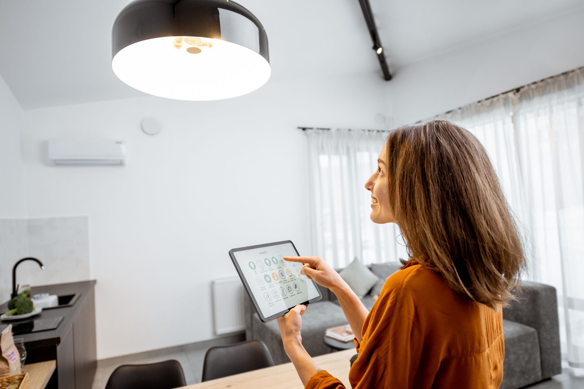A woman is using a tablet computer in a living room.