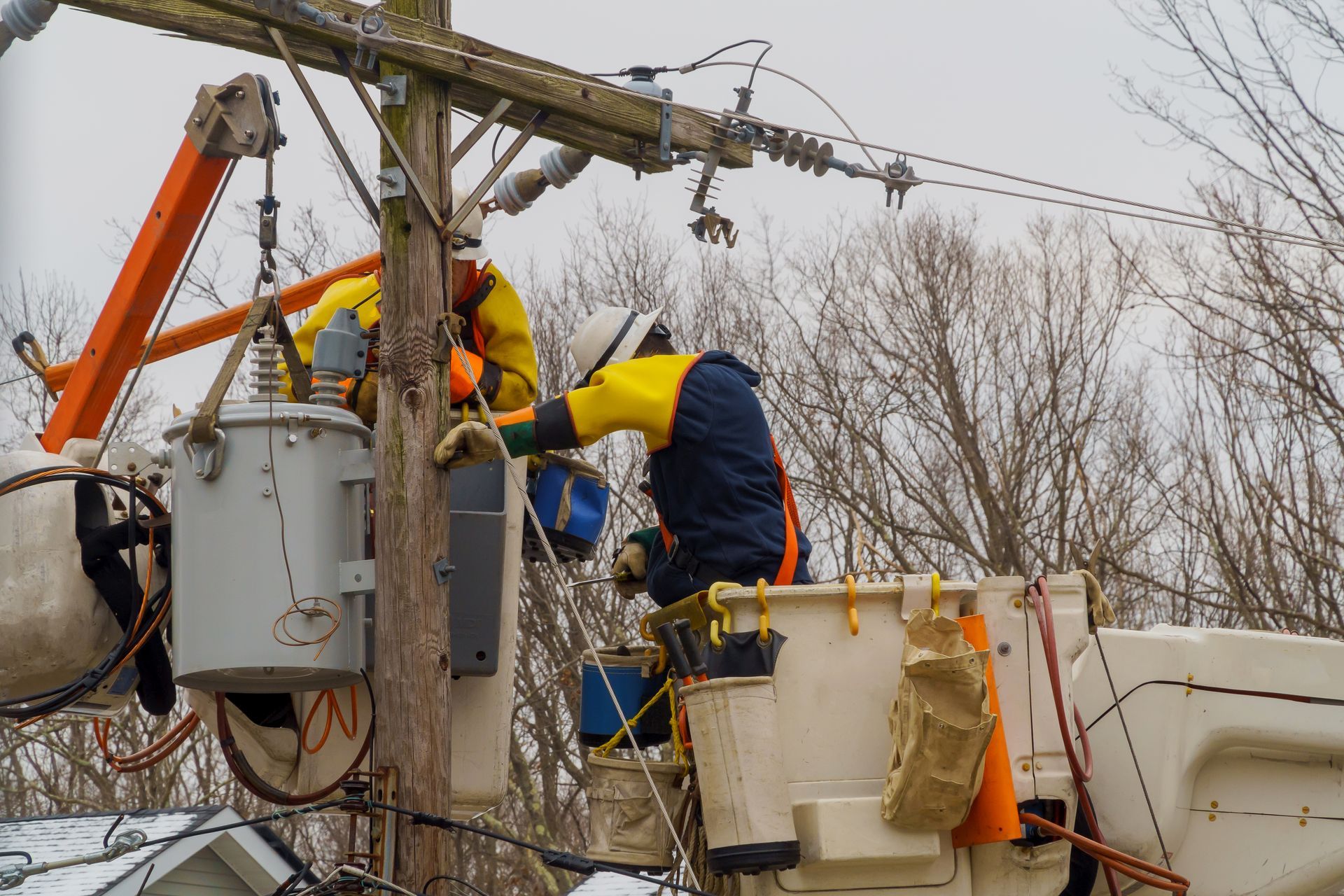 A man in a bucket is working on a power line.