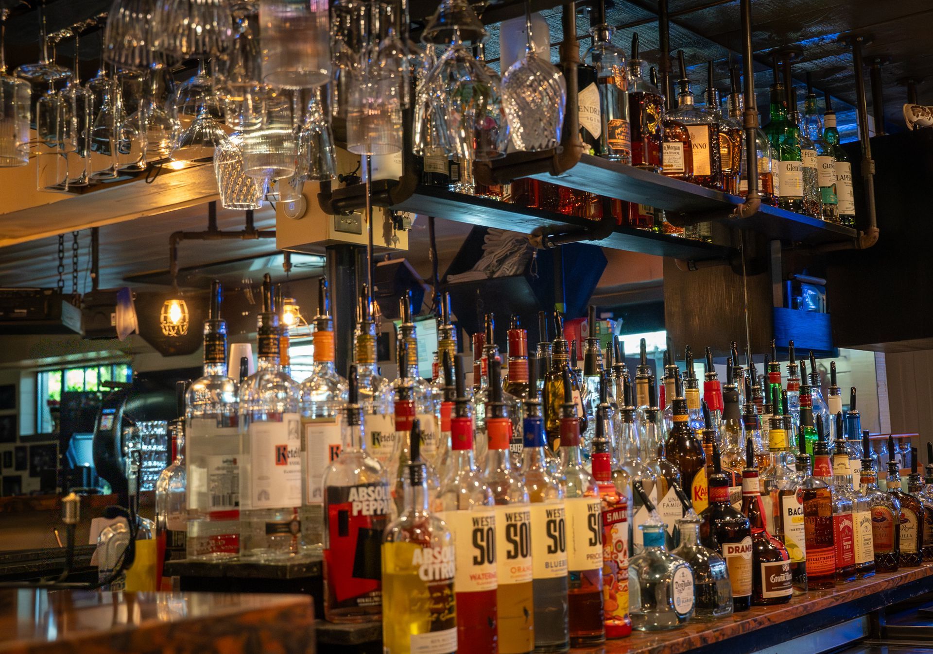 Bar with bottles of liquor and hanging glasses.