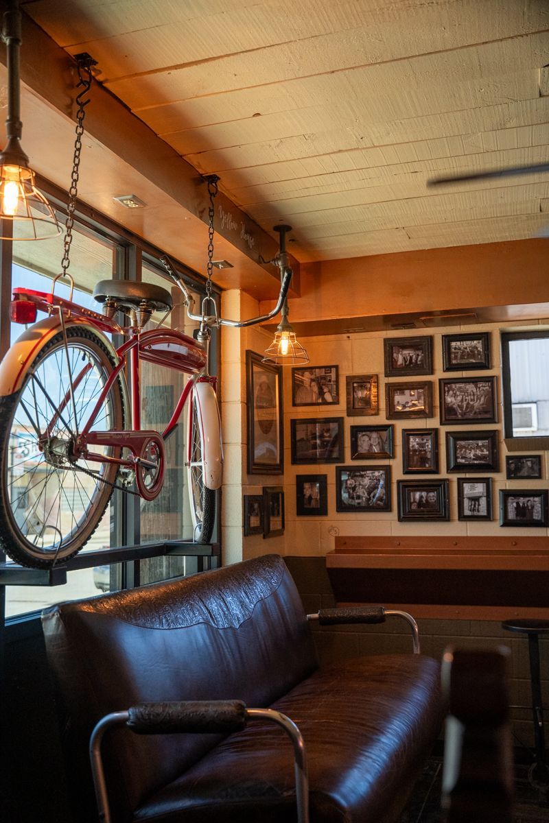 Fritz's bicycle was suspended near a leather couch in a room with vintage photos and industrial lighting.