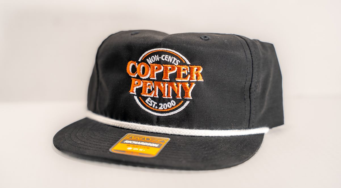 Black baseball cap with white rope and orange "Copper Penny" logo, Est. 2008.