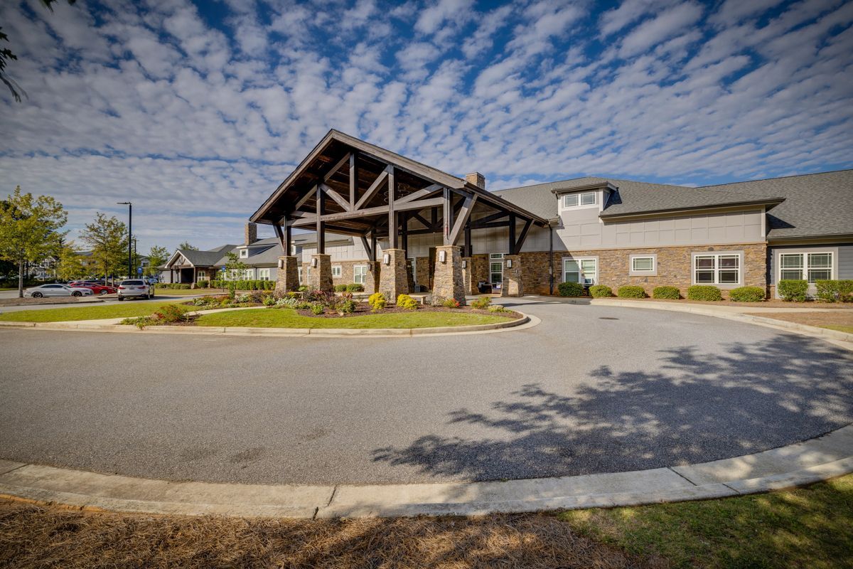 A large building with a wooden roof and a driveway in front of it.