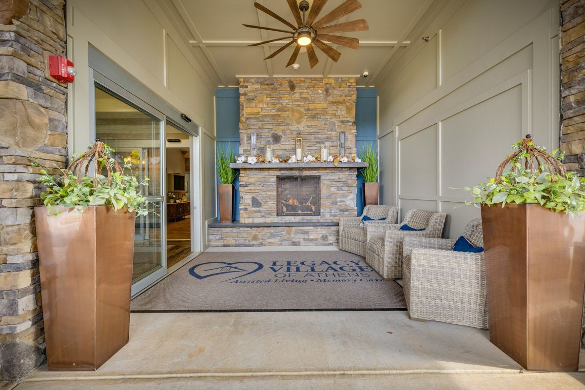 A hotel lobby with a fireplace and a ceiling fan.