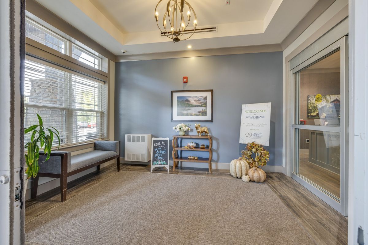 A large room with a lot of windows and pumpkins on the floor.