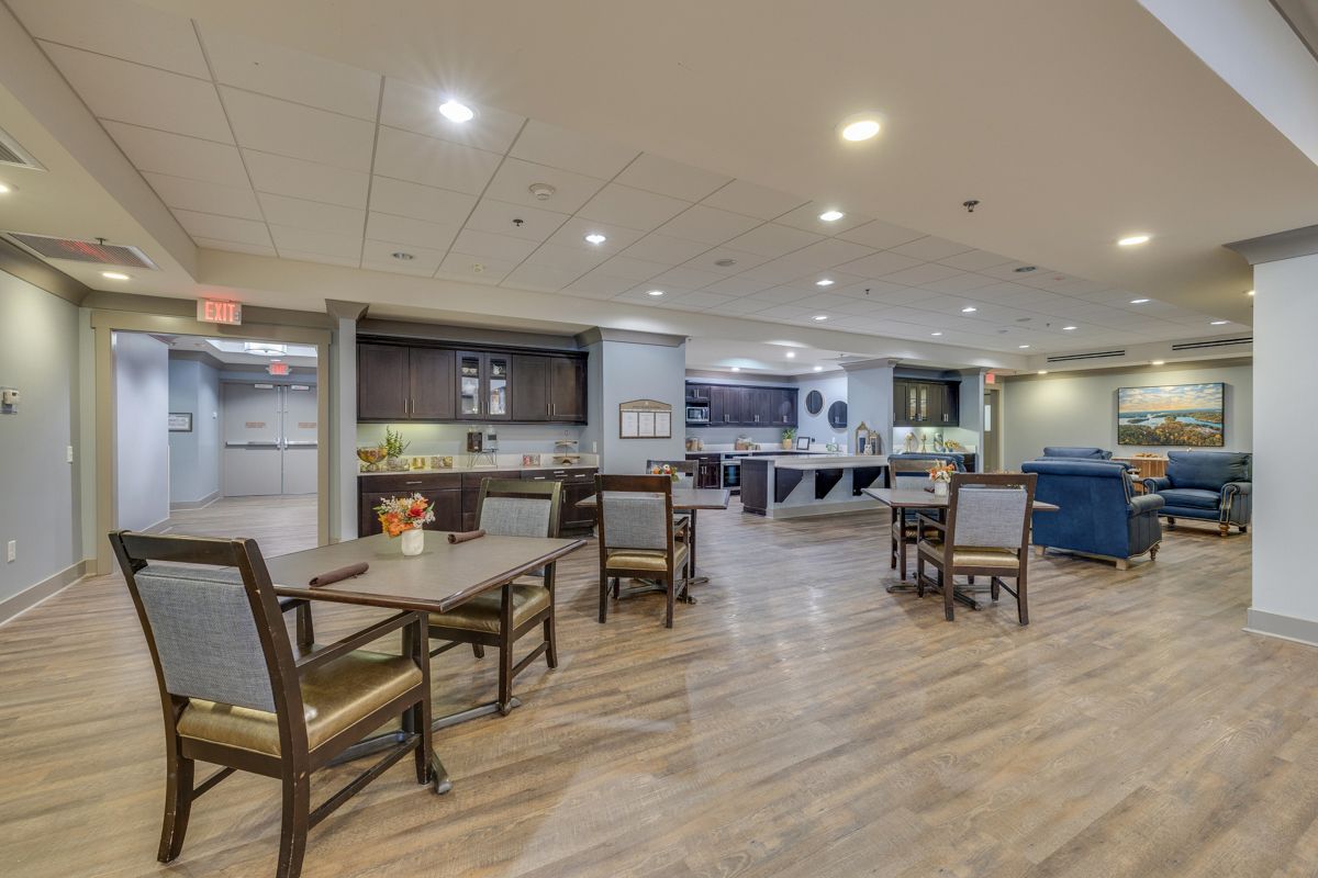 A large room with tables and chairs in a nursing home.
