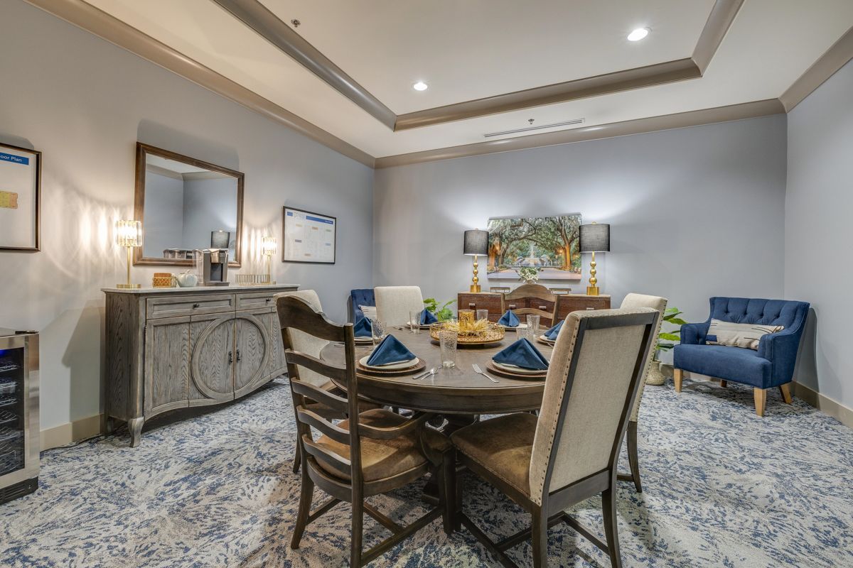 A dining room with a table and chairs and a dresser.