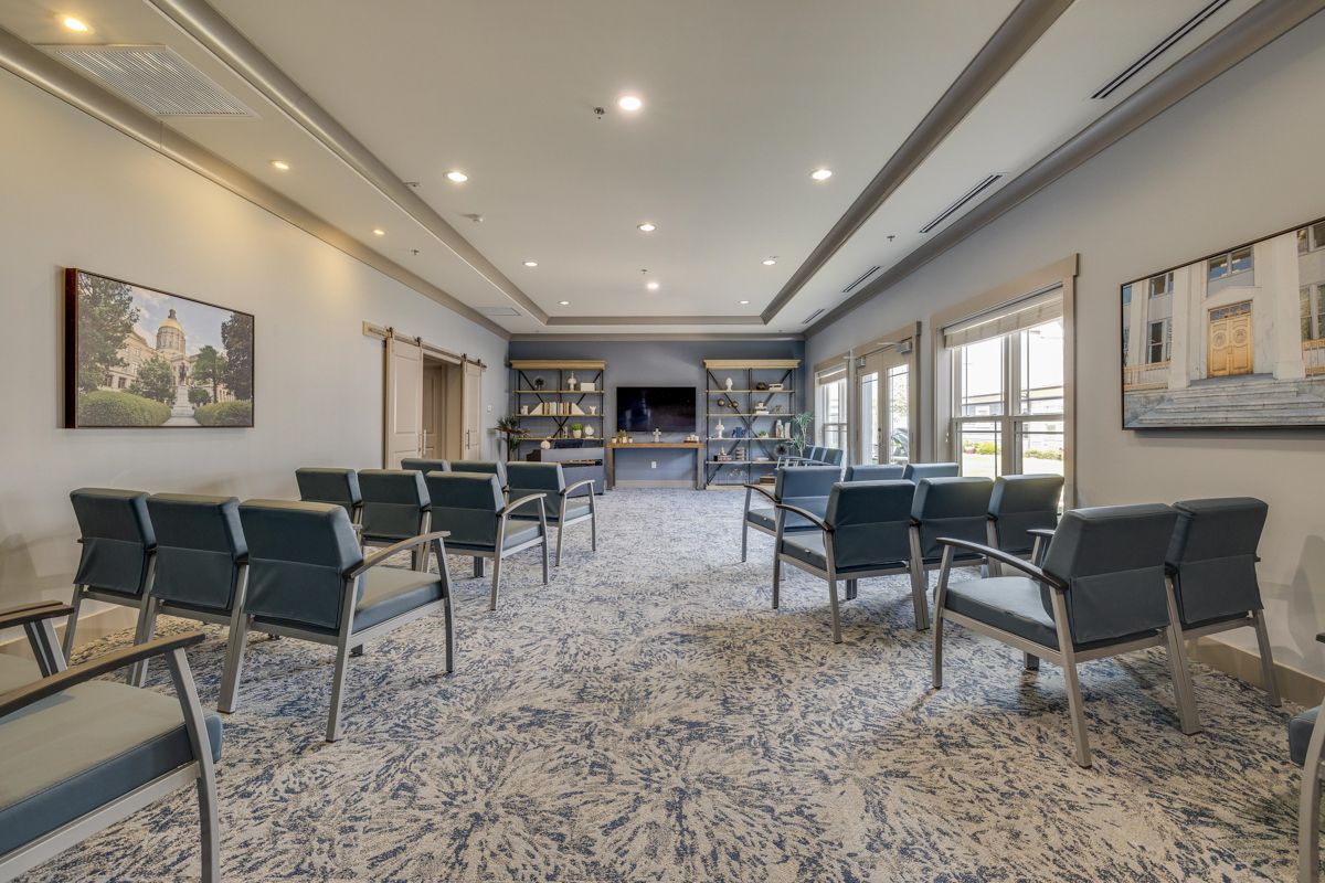 A large room with a lot of chairs and a television on the wall.