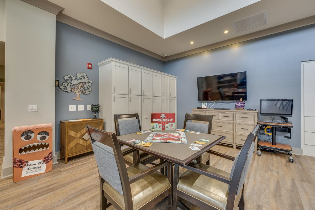 A room with a table and chairs and a television.