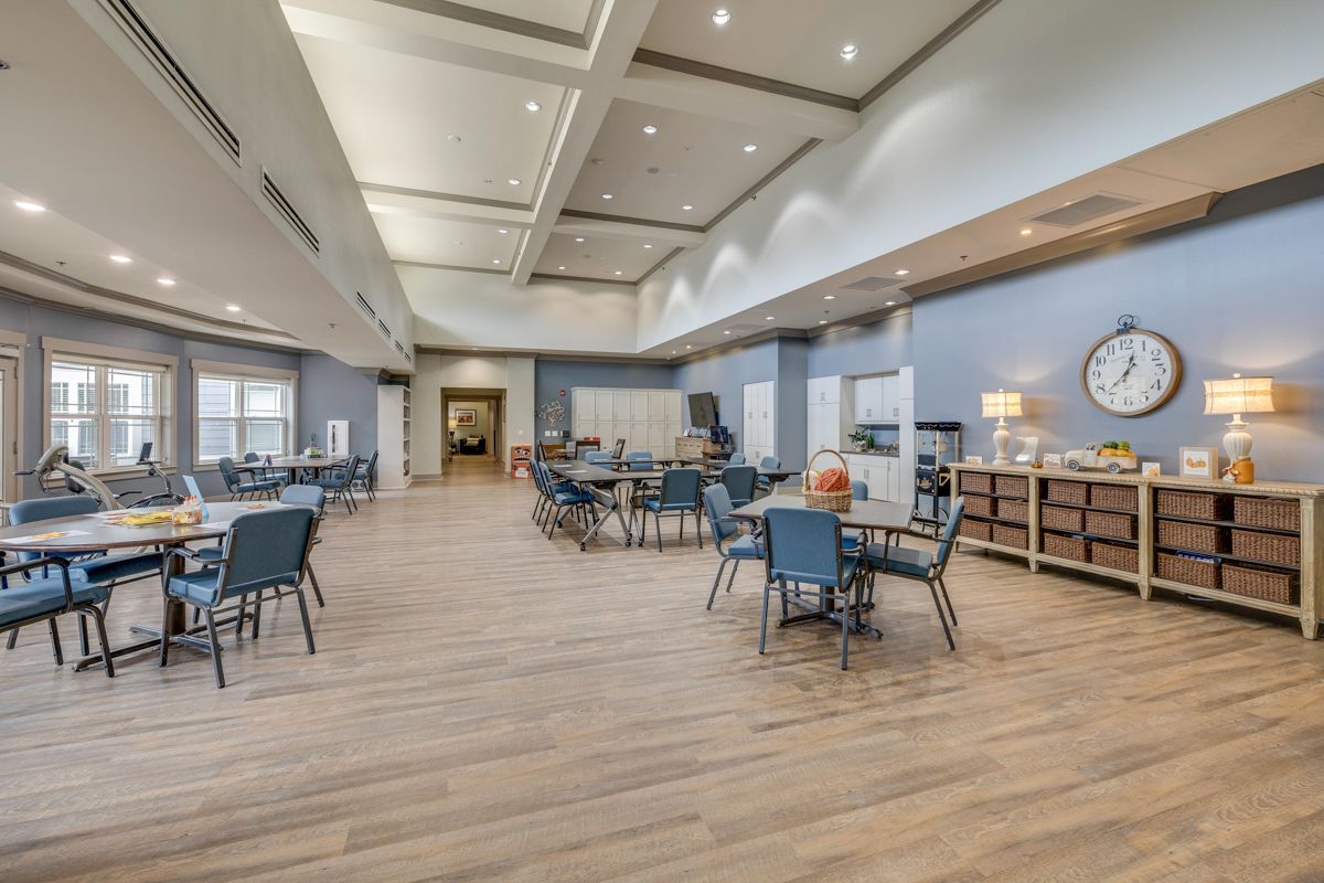 A large dining room with tables and chairs and a clock on the wall.