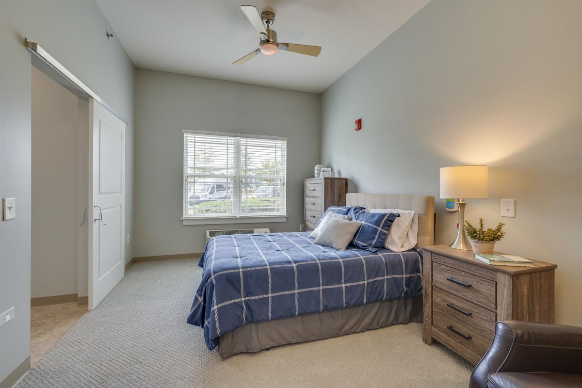 A bedroom with a large bed and a ceiling fan