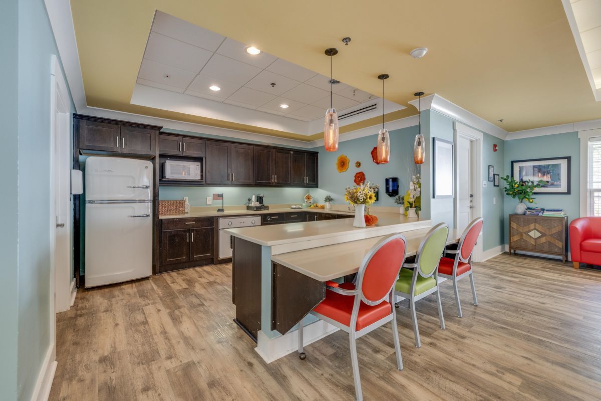 A kitchen with a table and chairs in it and a refrigerator.
