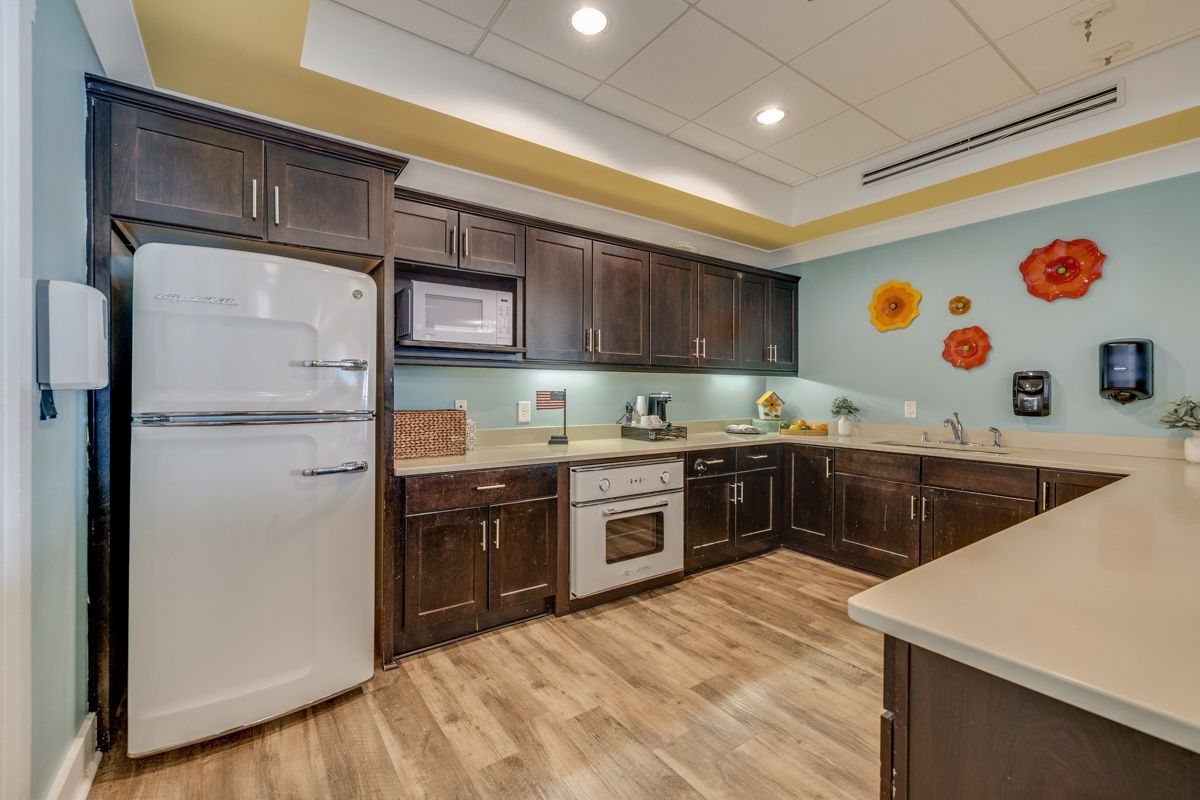 A kitchen with a refrigerator , stove , microwave and sink.