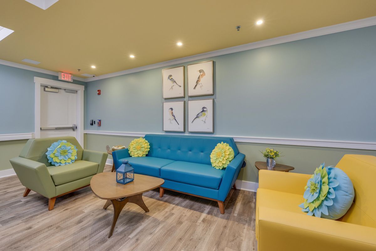 A living room with a blue couch and yellow chairs