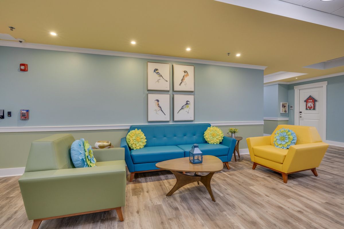 A living room with a couch , chairs , and a coffee table.