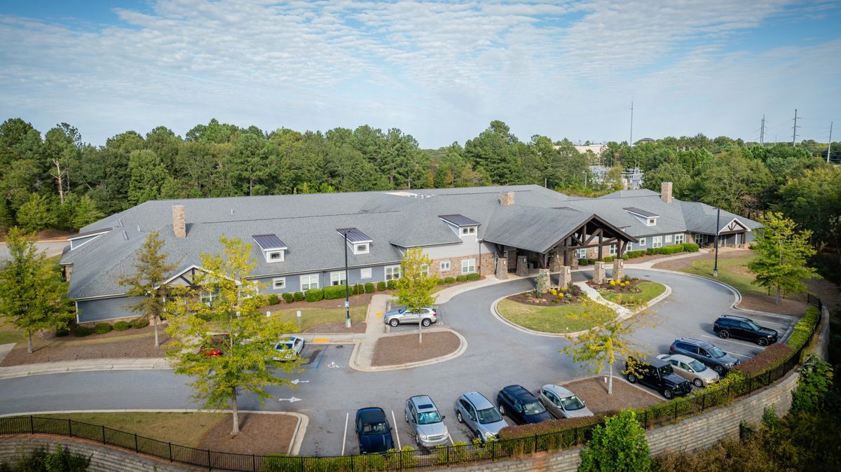 An aerial view of a large building with a lot of cars parked in front of it.