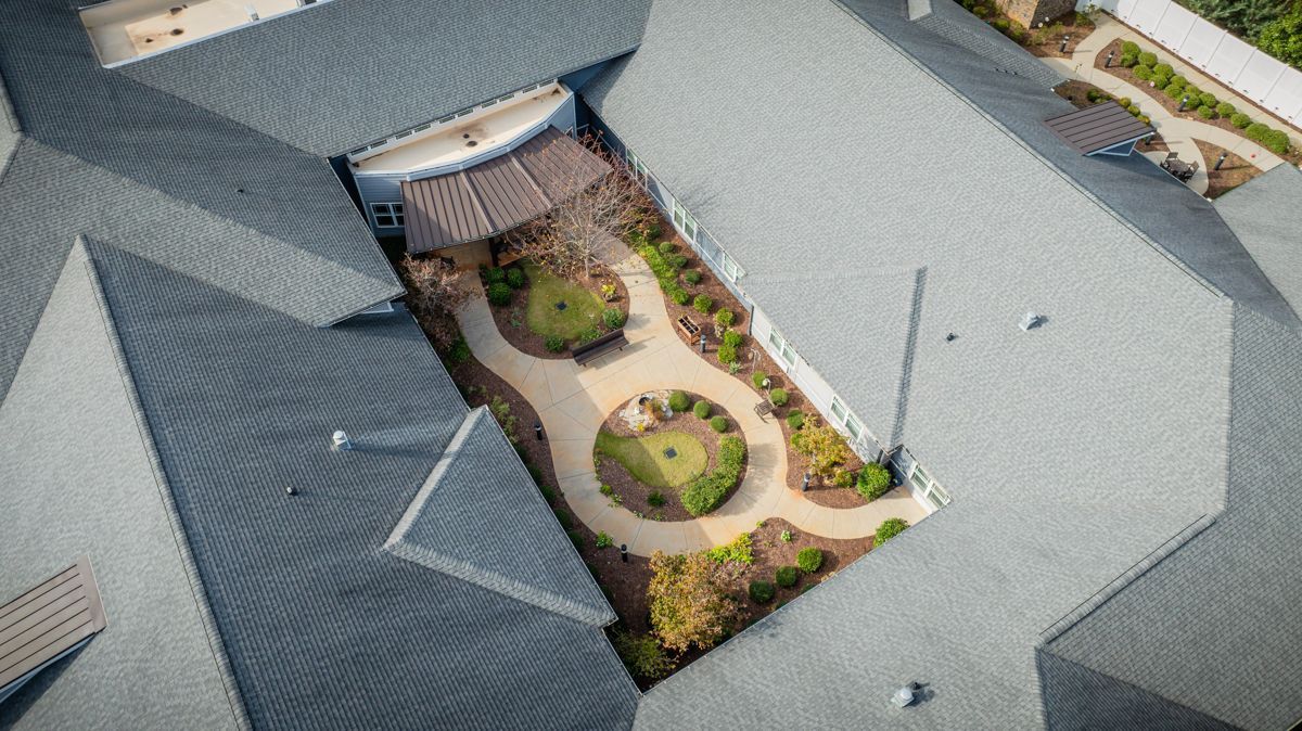 An aerial view of a large building with a golf course in the middle of it.