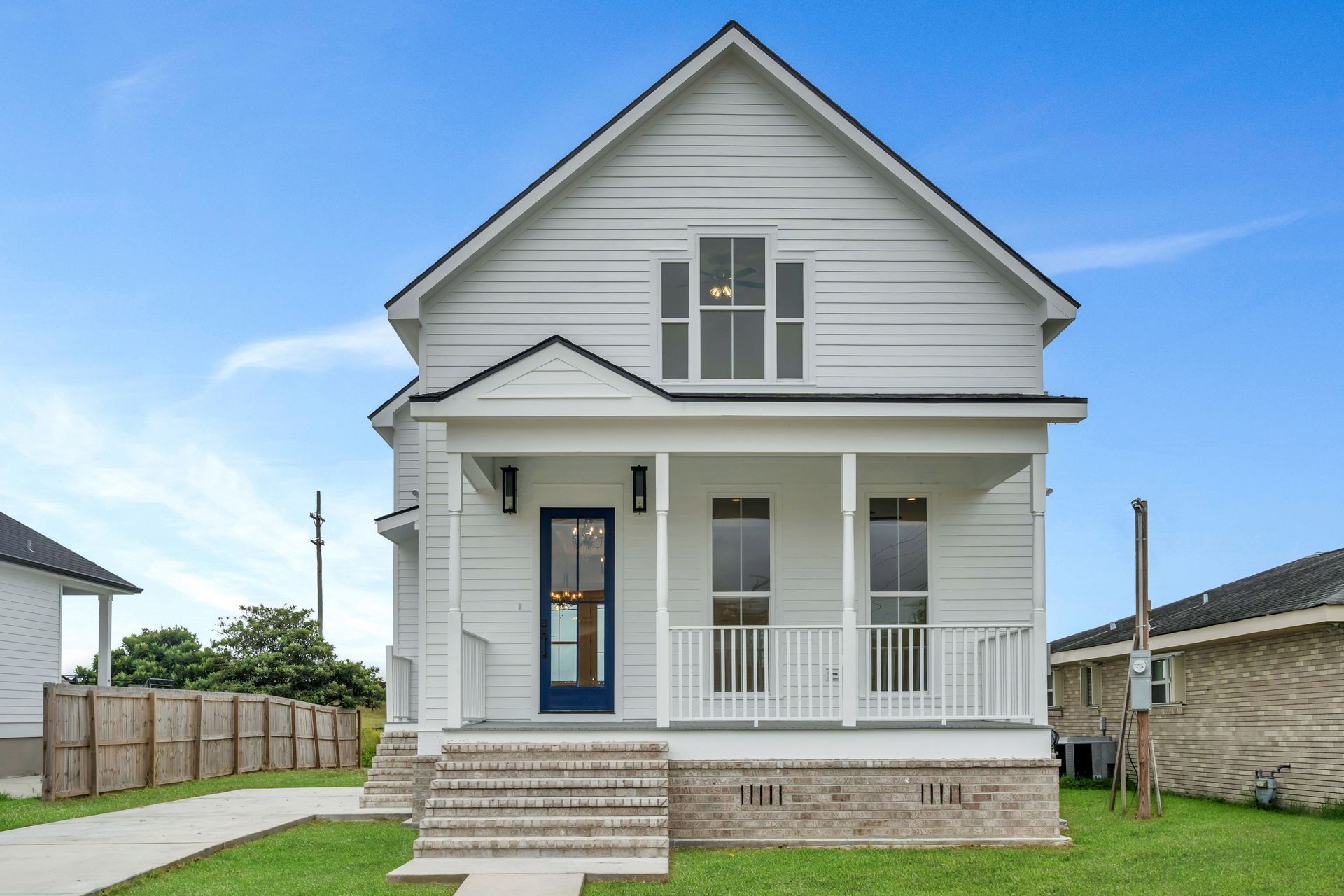 A white house with a blue door and porch