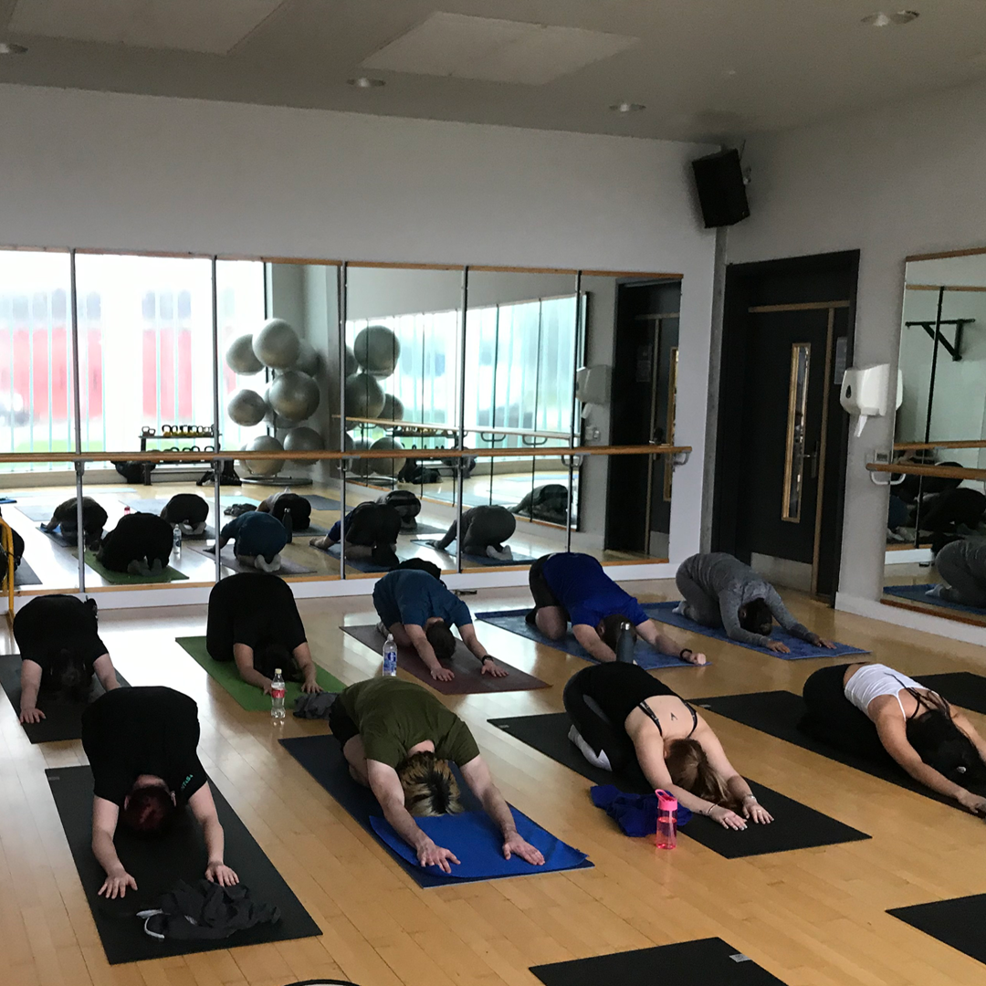 Work colleagues lying on a yoga mats in a class