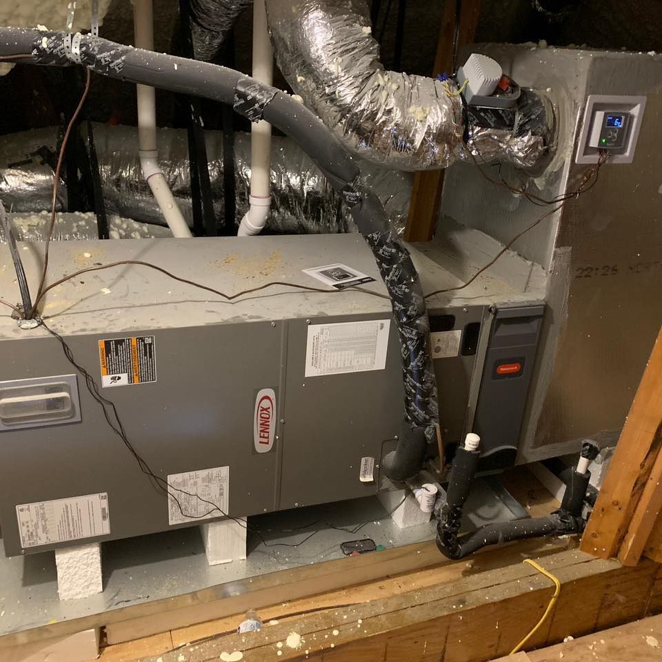 An air conditioner is sitting in the attic of a house.