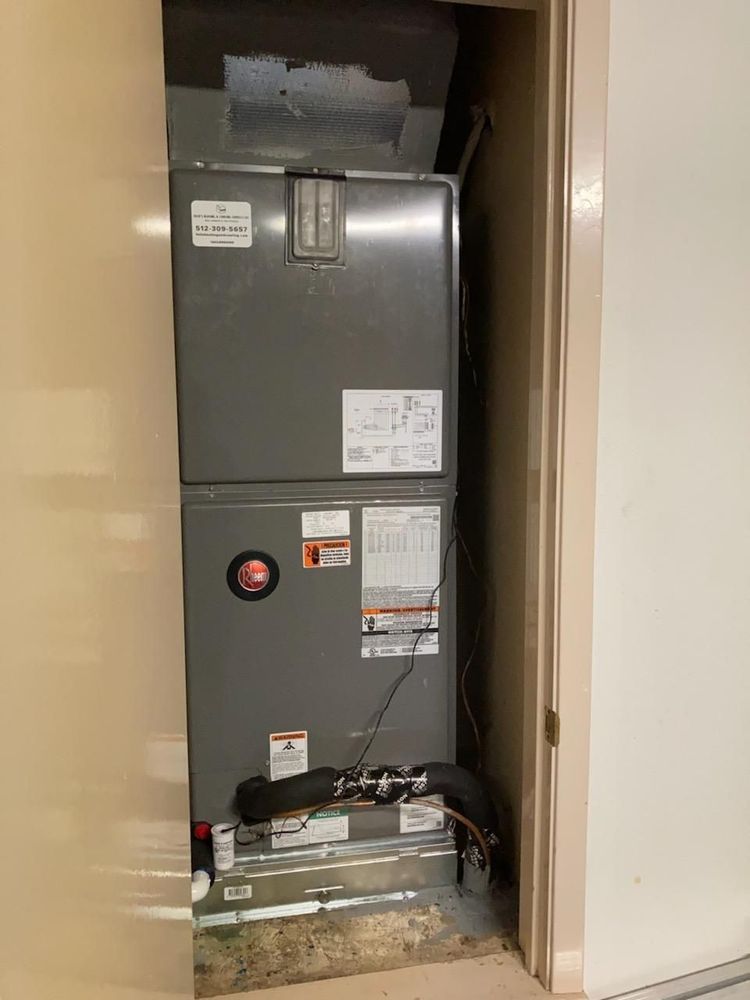 An air conditioner is sitting inside of a room next to a door.