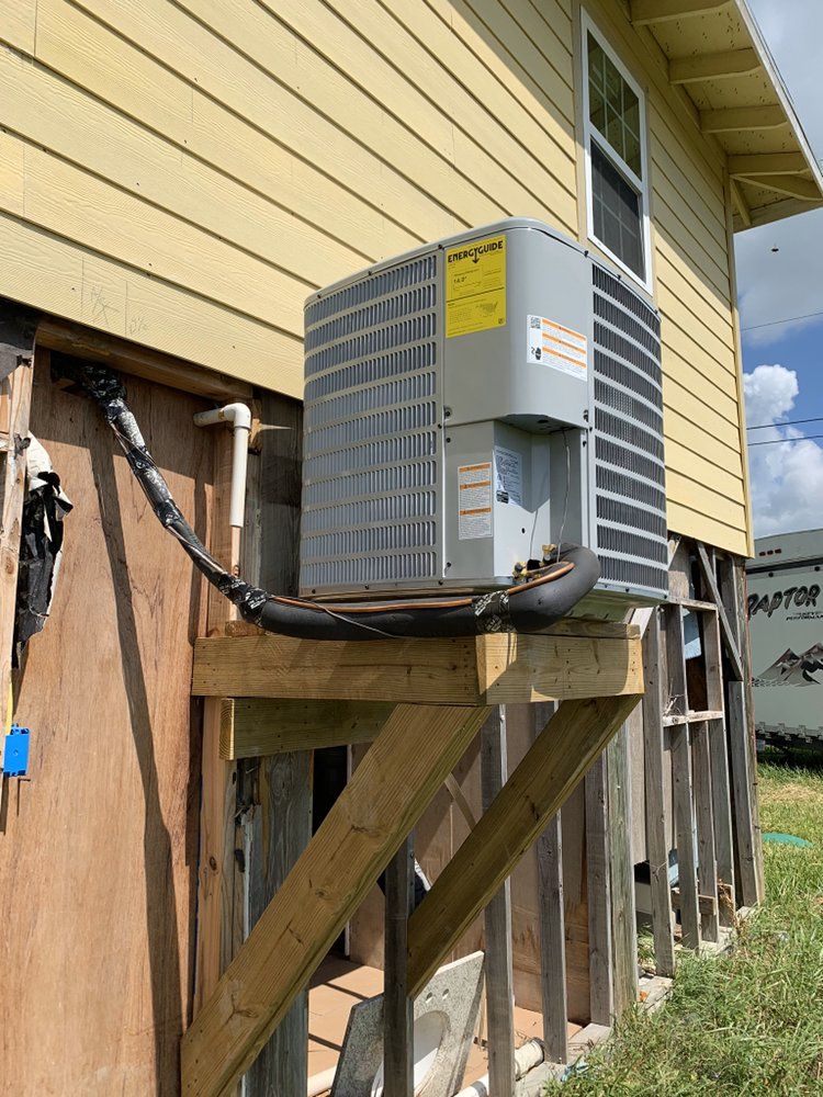 A large air conditioner is mounted on the side of a house.