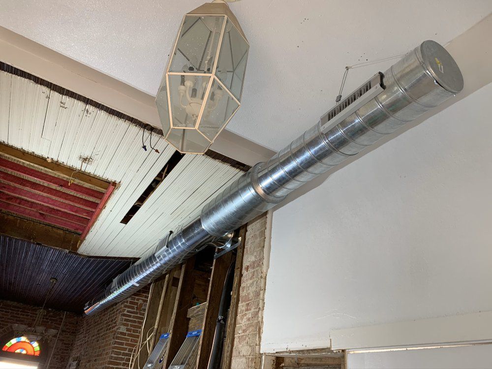 A large metal pipe is hanging from the ceiling of a building.