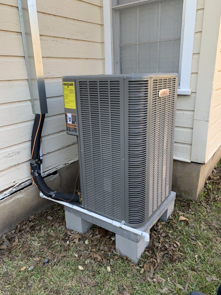An air conditioner is sitting on the side of a house.