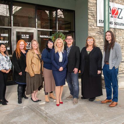 A group of people are posing for a picture in front of a building.