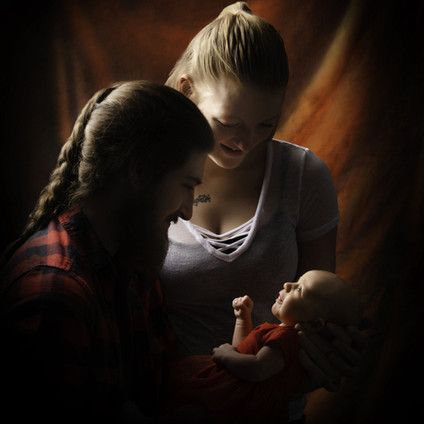 A man and a woman are holding a baby in their arms