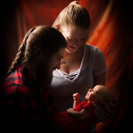 A man and woman are holding a baby in their arms