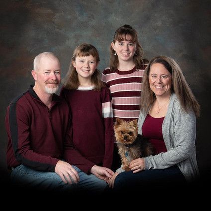 A family posing for a picture with their dog