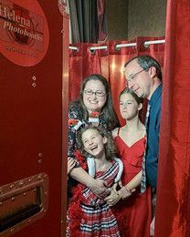 A family is posing for a picture in a photo booth.