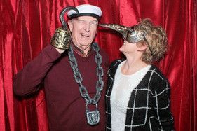 A man and a woman are posing for a picture in a photo booth.