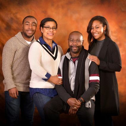 A group of people posing for a picture with one of them wearing a jacket with the letter m on it