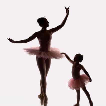 A silhouette of a mother and daughter dancing ballet