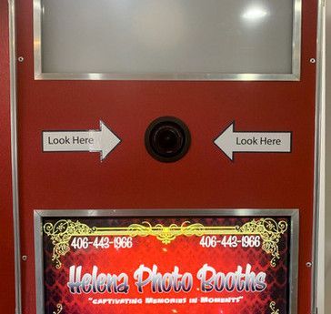 A red photo booth with a sign that says helena photo booths