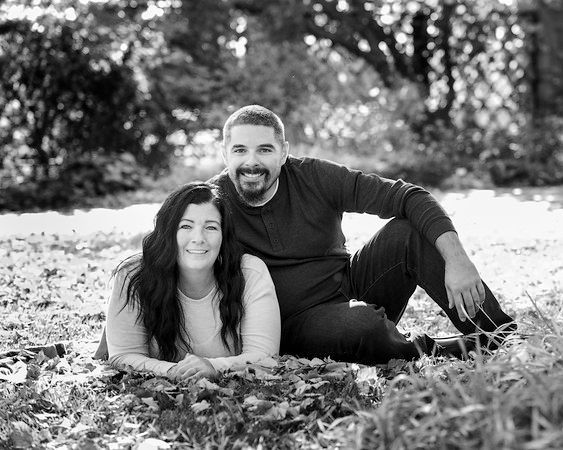 A black and white photo of a man and woman laying in the grass.