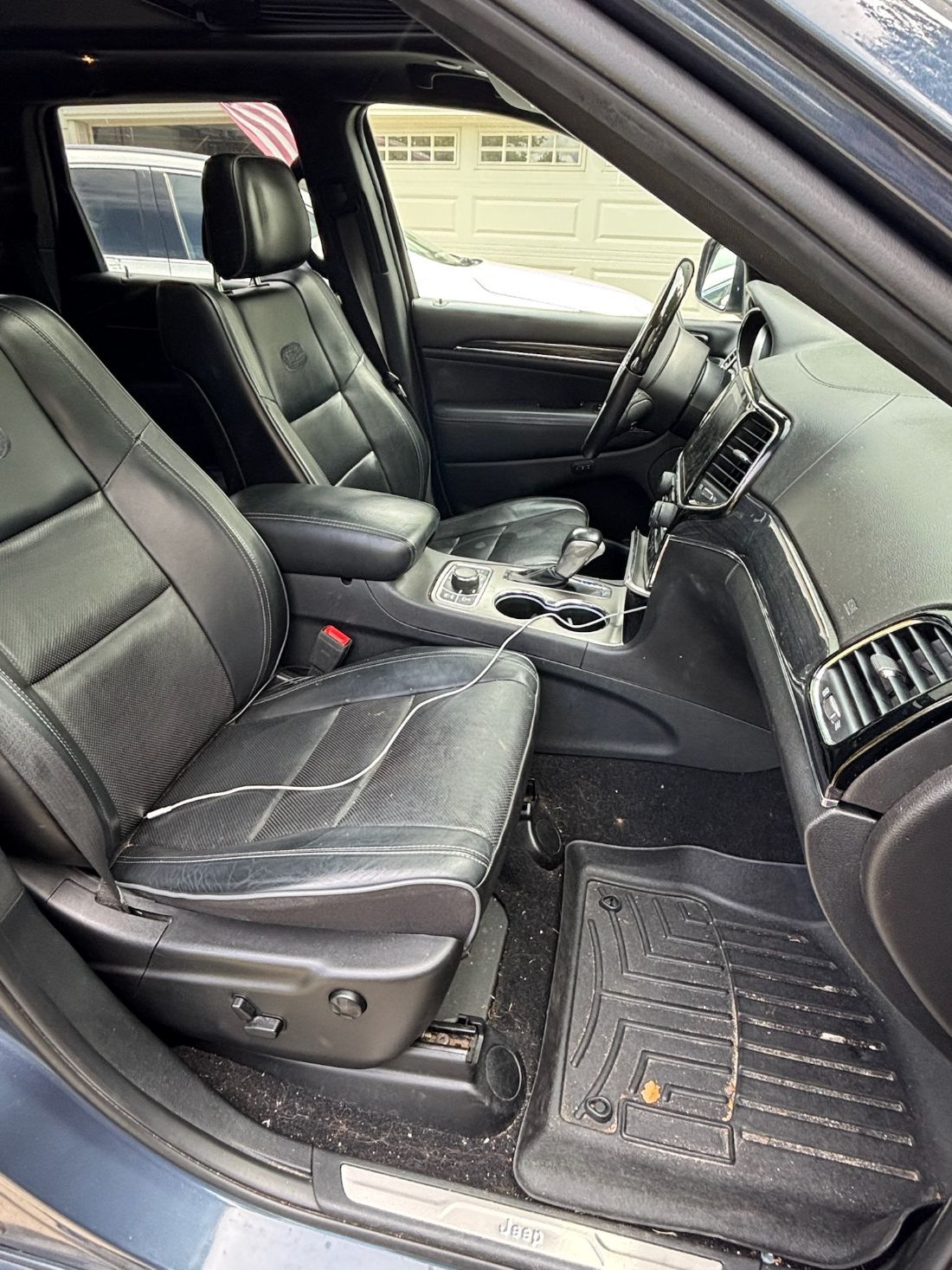 Before slider of a Tesla interior professionally detailed by Gold Standard Mobile Detailing in Bala Cynwyd.