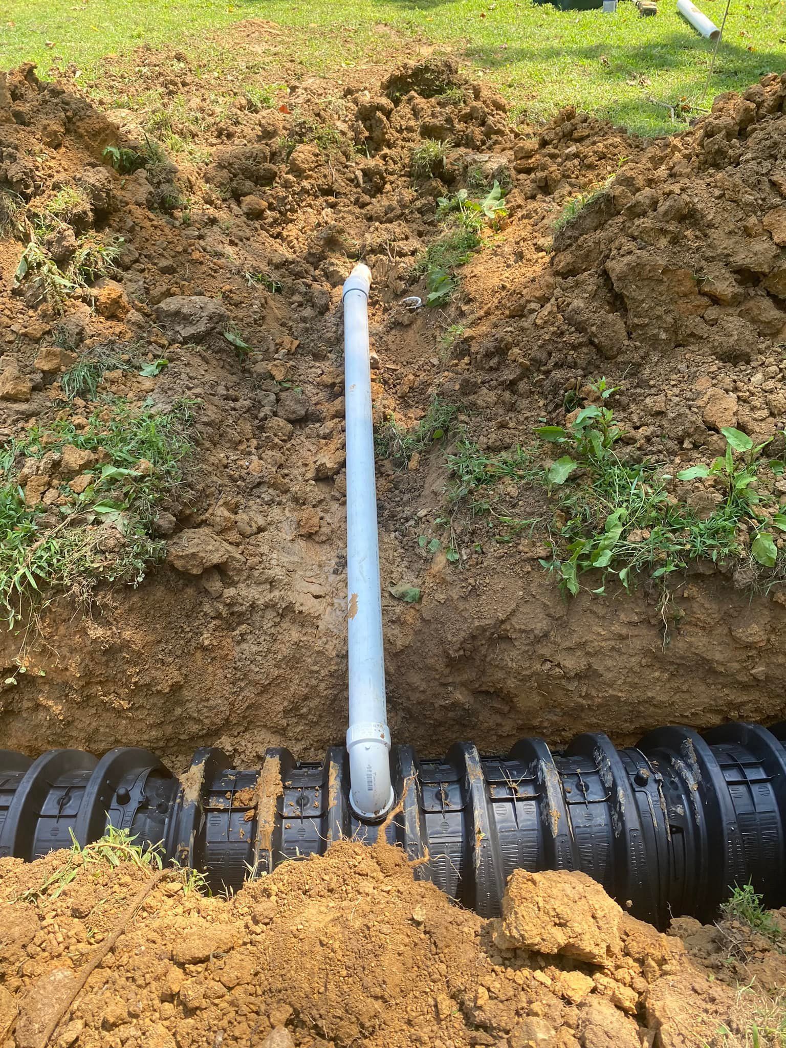 A pipe is being installed in a hole in the ground.