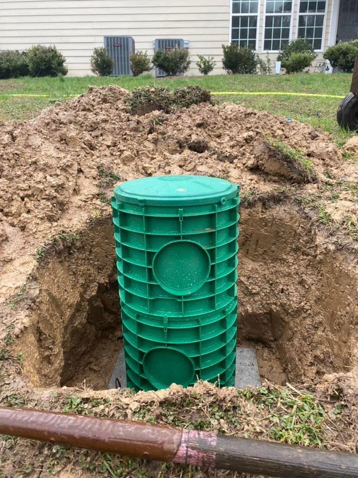 A green bucket is sitting in the middle of a hole in the ground.