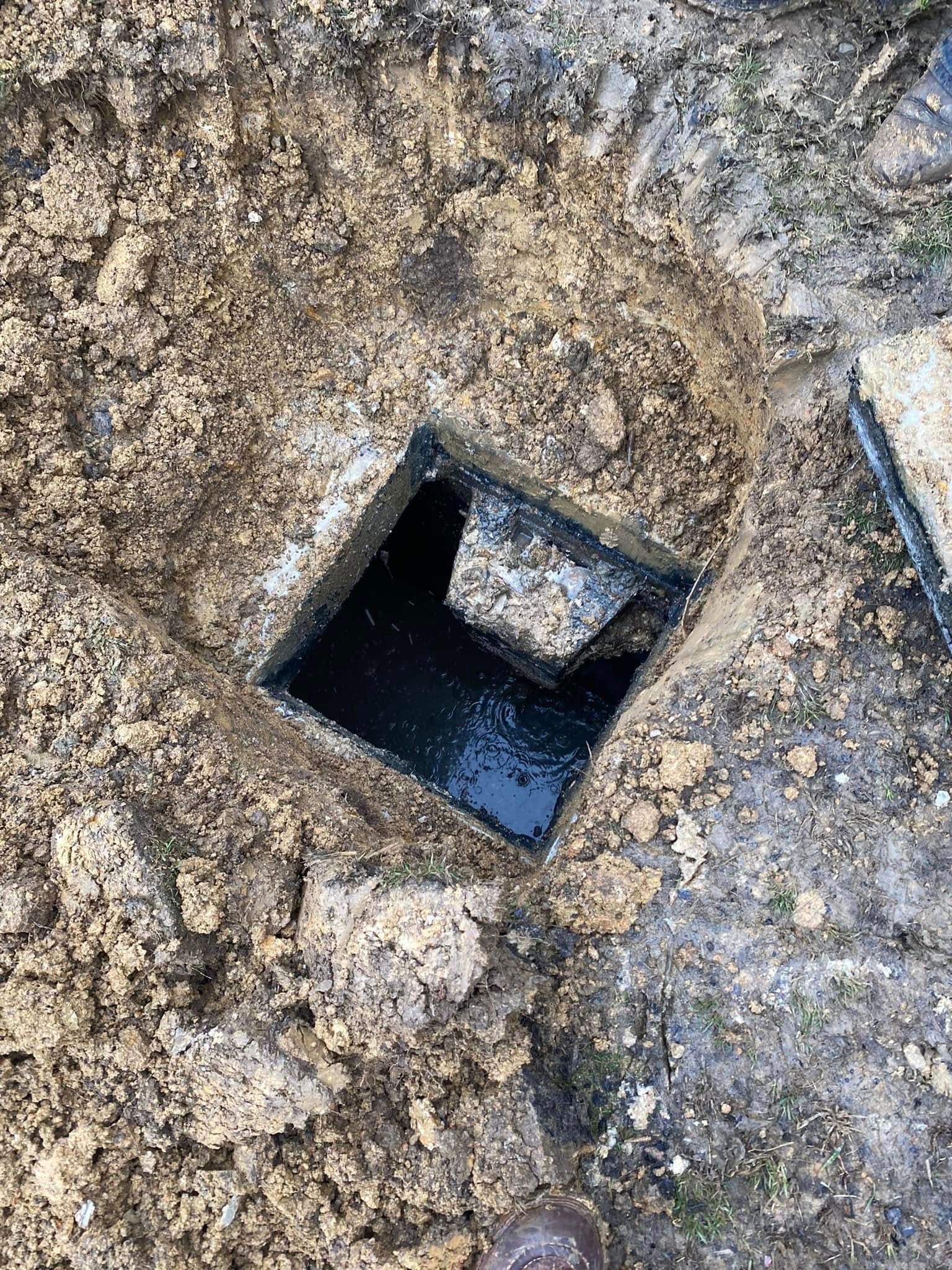 A hole in the ground with water coming out of it.