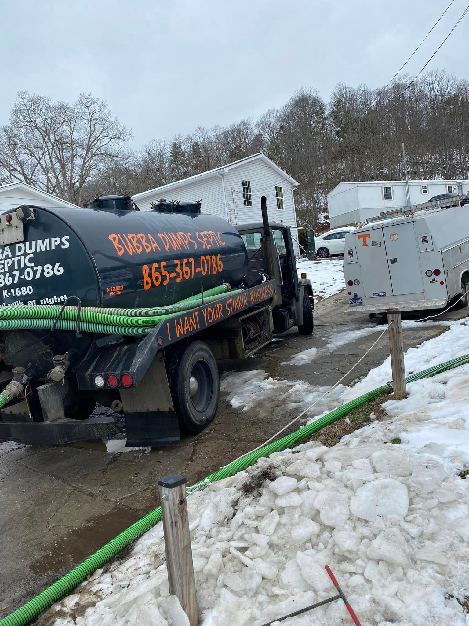 A tanker truck is parked on the side of the road in the snow.